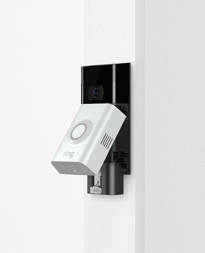 A Ring video doorbell with faceplate opened, revealing internal battery